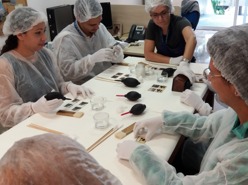 Equipe Pro Memória recebendo treinamento para higienização do acervo de diapositivos